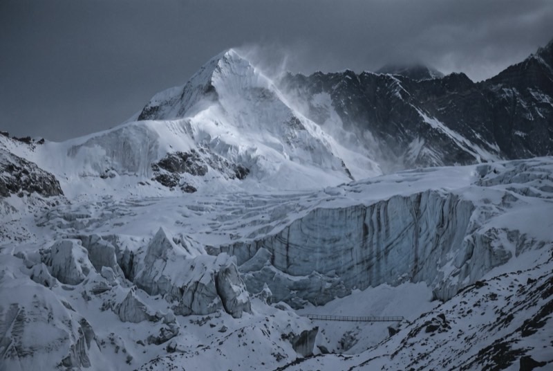 The snow and ice summit pyramid of Island Peak rising above its crevassed glacier basin at first light.